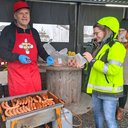 Mies tarjoilee grillimakkaraa TAKKin Loistoduunissa.