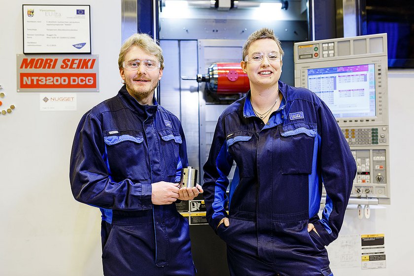 Koneistajat ja 5-akselinen Mori Seiki sorvi Koneistajat poseeraavat 5-akselisen Mori Seiki sorvin edessä