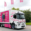 Sähköverkkoalan yhteistyöfoorumi - tervetuloa! Puna-valkoinen sähkökuorma-auto takana liehuu TAKKin punaiset liput.