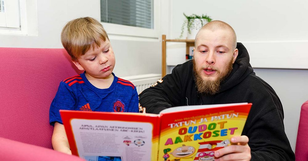 Pikkupoika ja mies lukevat lastenkirjaa
