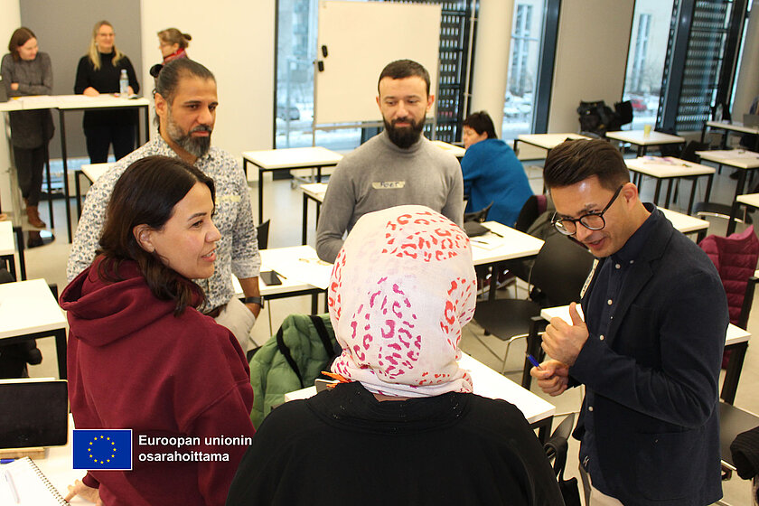 Ihmiset keskustelevat ringissä luokkahuoneessa.