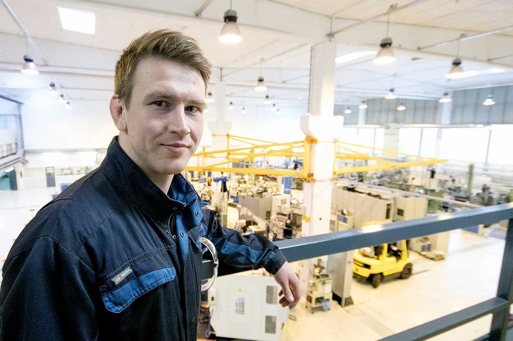Jussi-Pekka Niemistö nojaa kaiteeseen TAKKin koneistushallin parvella