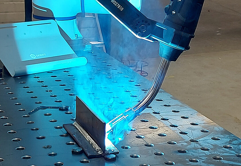 Hitsaus-cobotti hitsaa metallikappaletta.