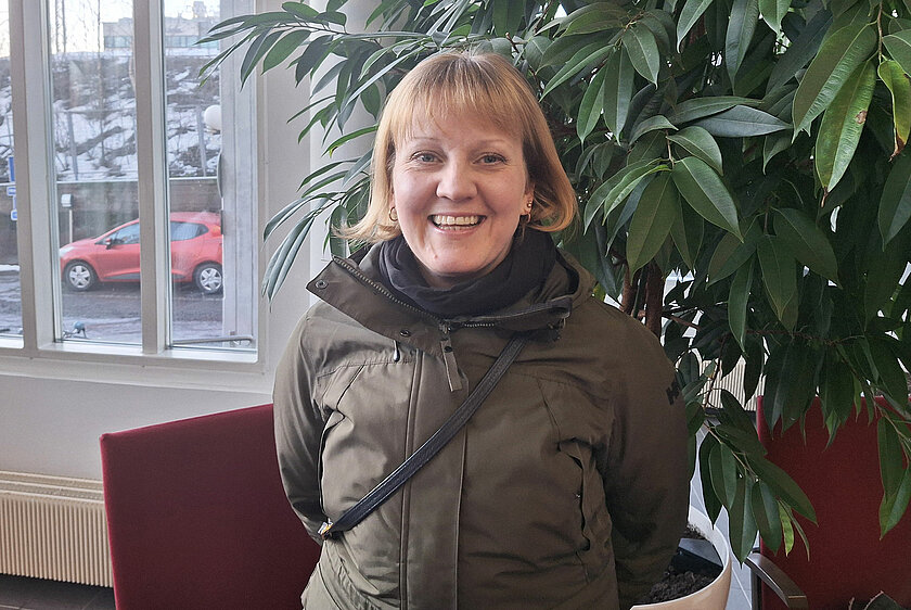 Henkilö katsoo iloisesti hymyillen kameraan Loistoduuni-tapahtumassa..