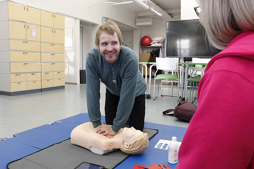 Henkilö antaa paineluelvytystä ensiapunukelle Loistoduuni-tapahtumassa.
