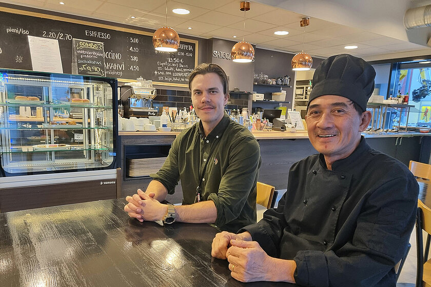 Peter ja Vincenth istuvat ravintolapöydän ääressä. 