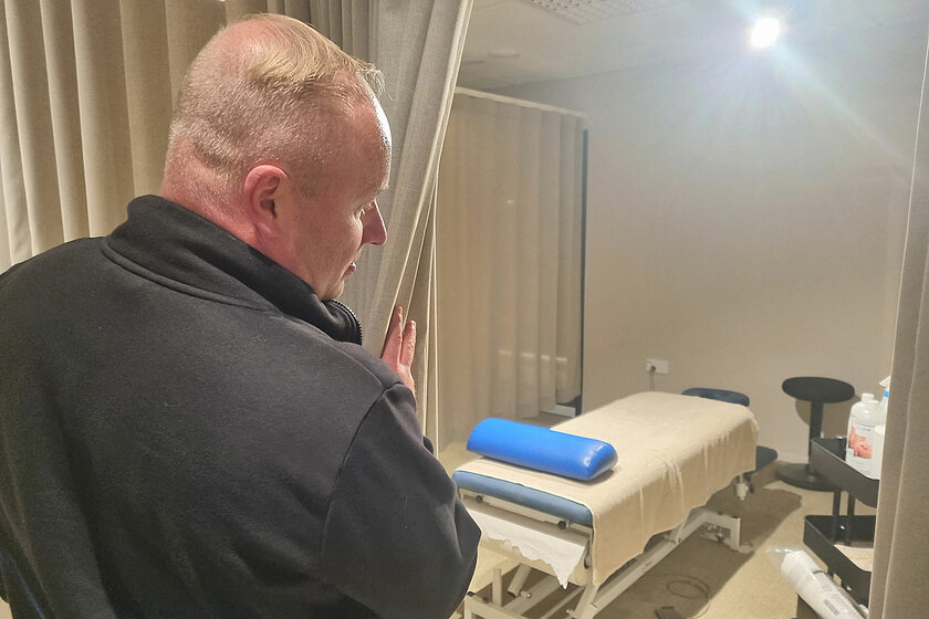 Markus Kuusijoensuu esittelee kurkkaa verhon takaa hierontapisteelle.