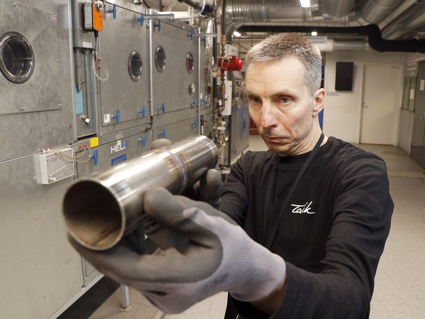 Mies katselee ja tutkii metallilieriön hitsaussaumaa.