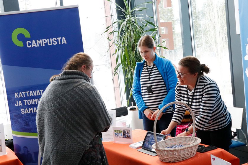 Campustan edustajat raitapaidoissaan jututtavat tilaisuuden kävijää.