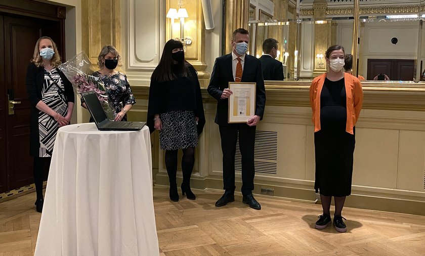 Merja Mattila, Satu Neuvonen, Tiina Holopainen, Teppo Tapani ja Li Andersson kunniakirjan kanssa maskit päässä.