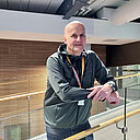 Henkilö nojaa lasikaiteeseen.