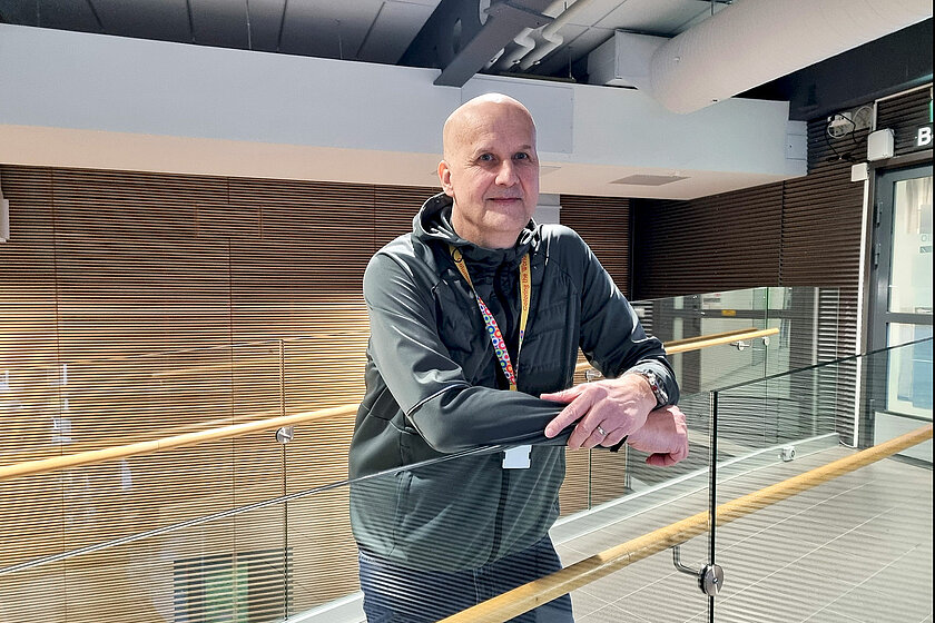 Henkilö nojaa lasikaiteeseen.