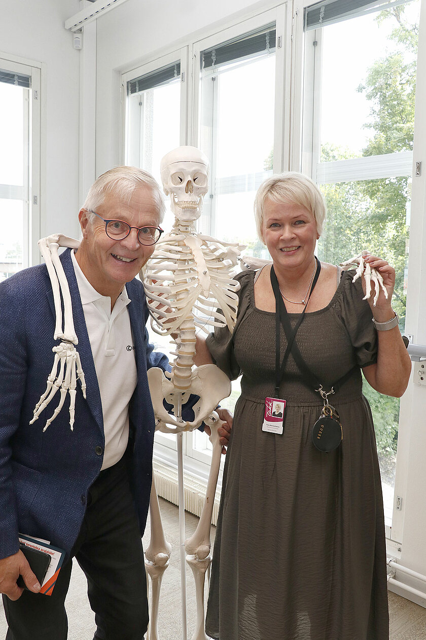 Rauno ja Tiina poseeraavat opetuksessa käytettävän luurangon kanssa.