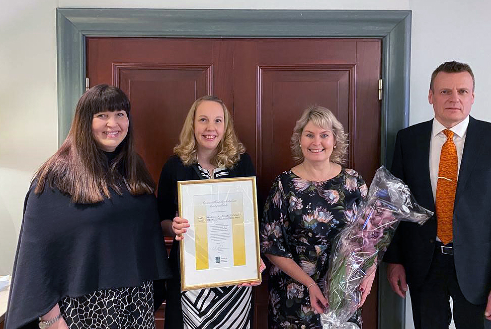 Four TAKK representatives holding the quality award.