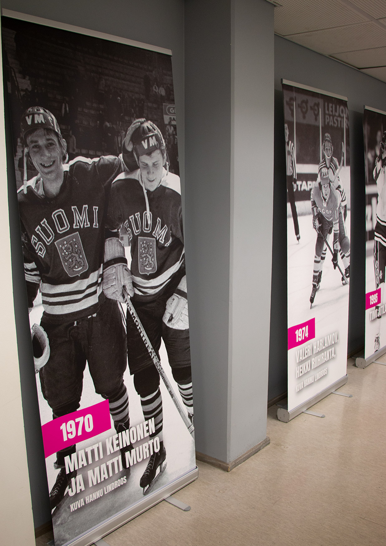 Mustavalkoisia kuvia Suomen pelaajista käytävän seinillä.