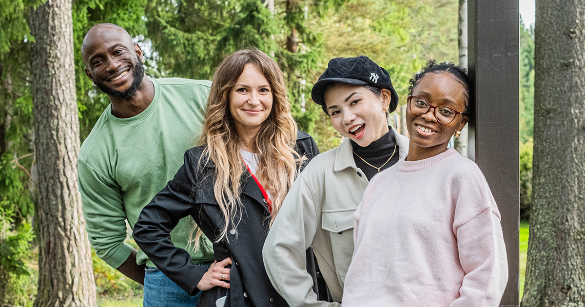 Kotoutuminen: 4 opiskelijaa hymyilee kameralle