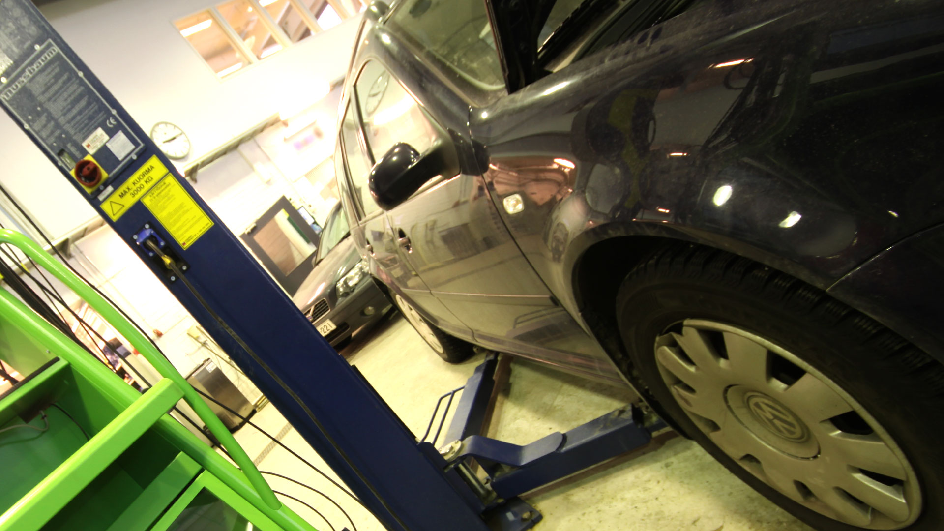 Autoalan koulutukset Musta henkilölöauto autokorjaamolla