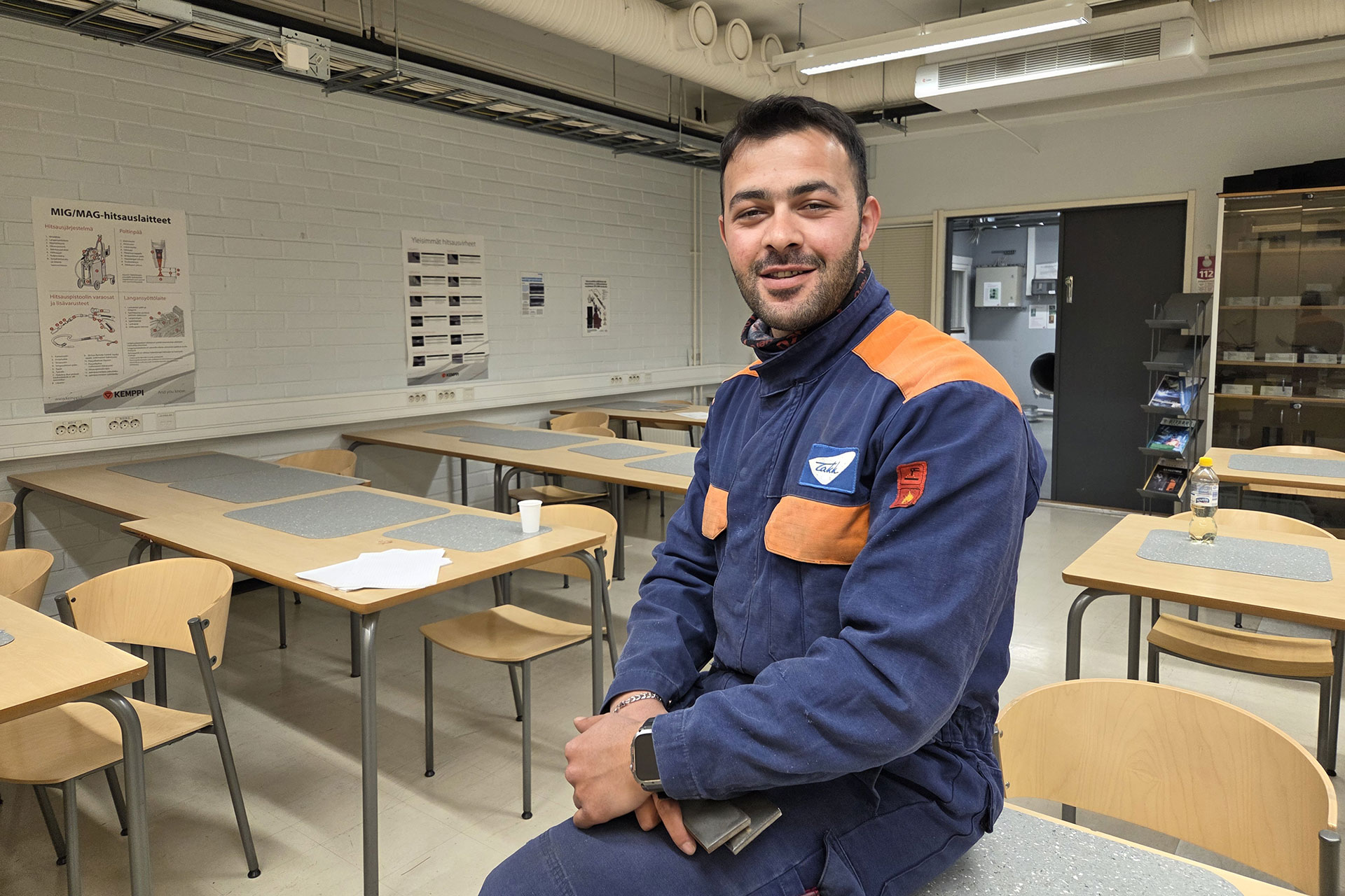 Halil istuu luokassa pulpetin kulmalla hitsaushaalarissaan.