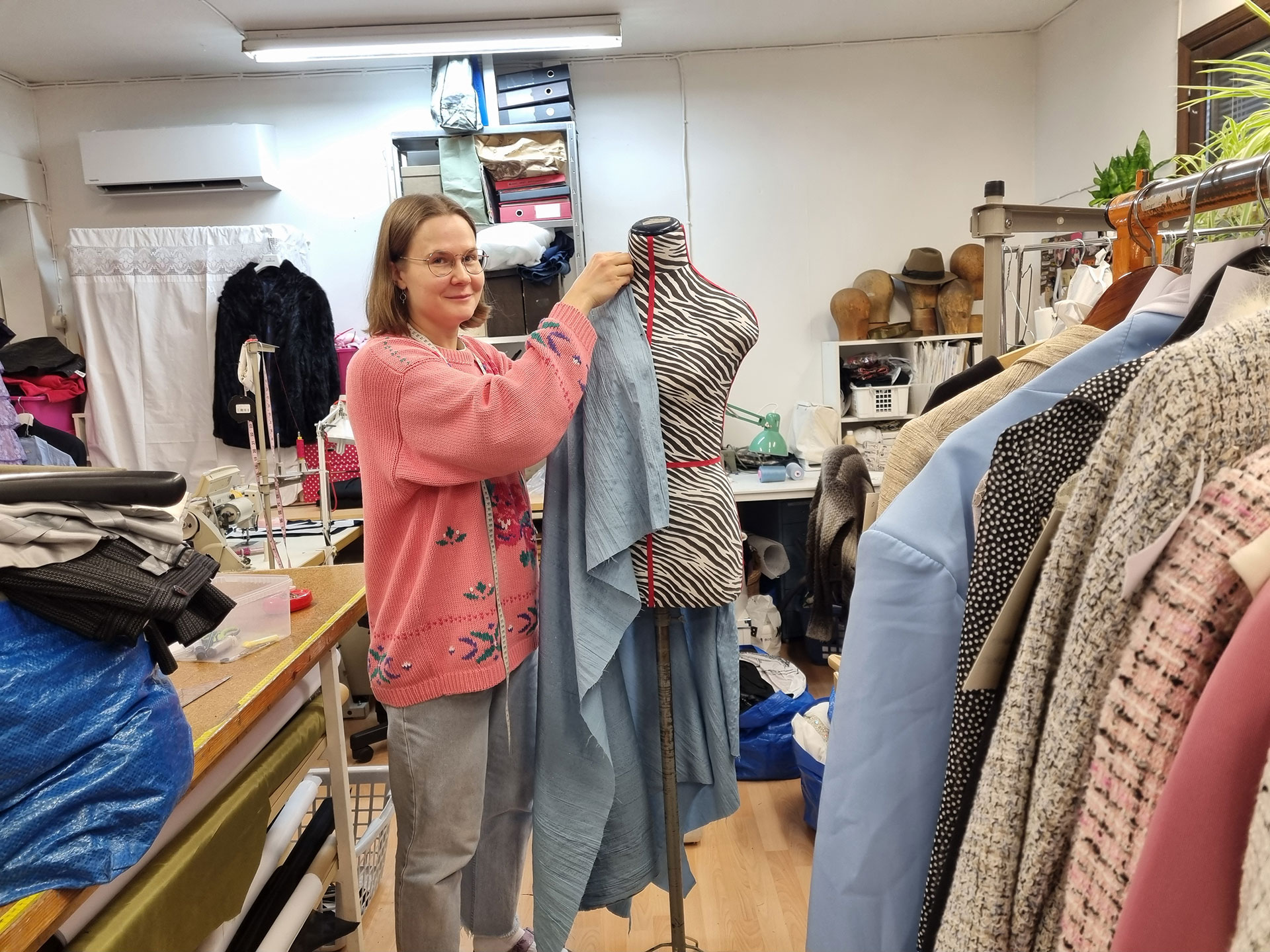 Liisa asettelee kangasta mallinuken päälle. 